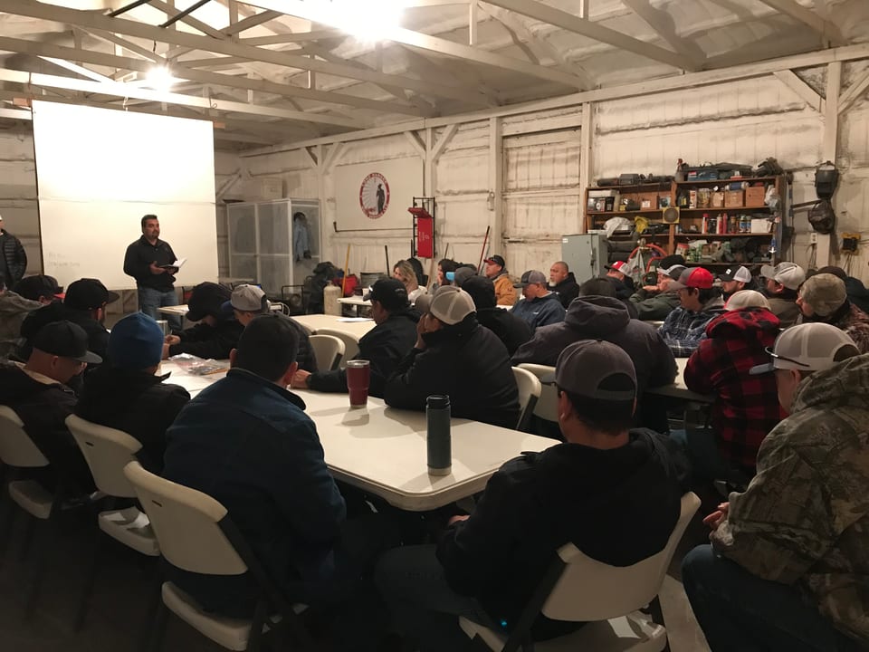 A client CEO briefing his crew at an all-hands meeting on the shop floor