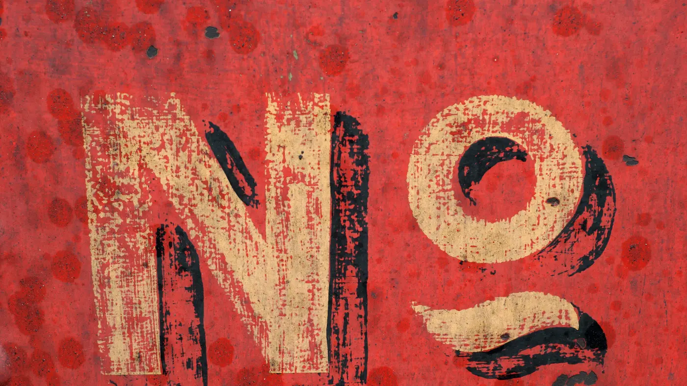 Weathered red sign with the word No