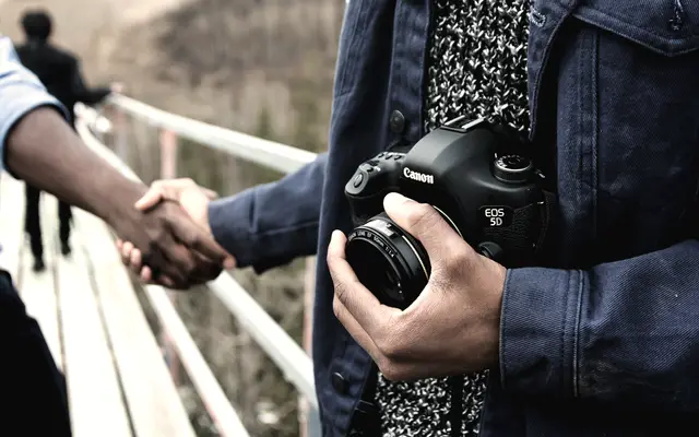 Two people shaking hands outdoors