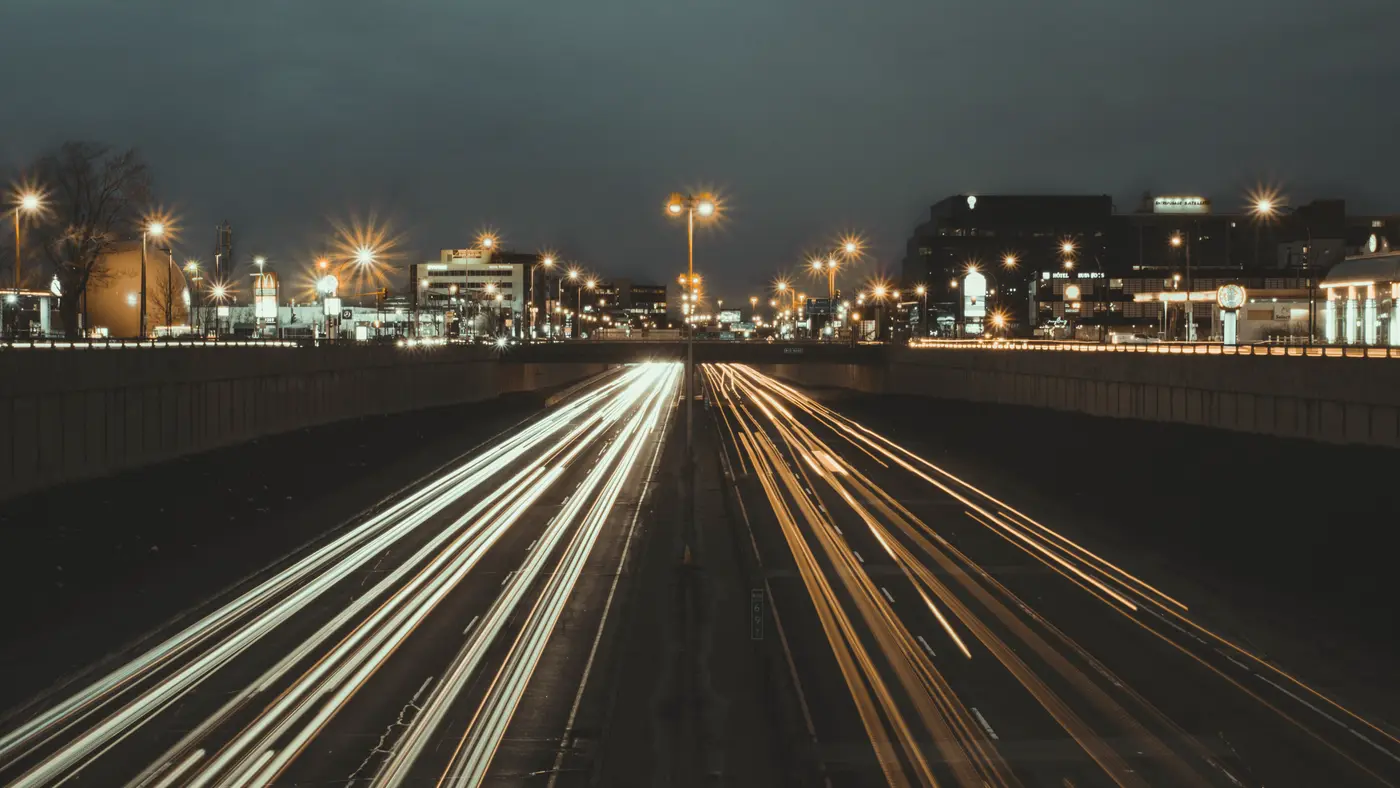 Long-exposure light trails of traffic on a highway at night