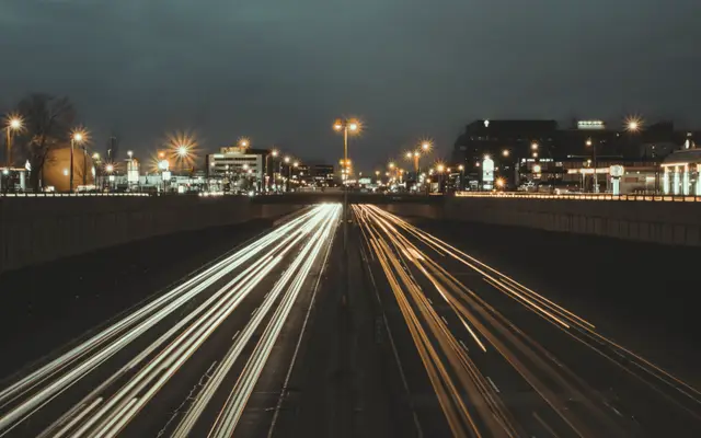 Long-exposure light trails of traffic on a highway at night