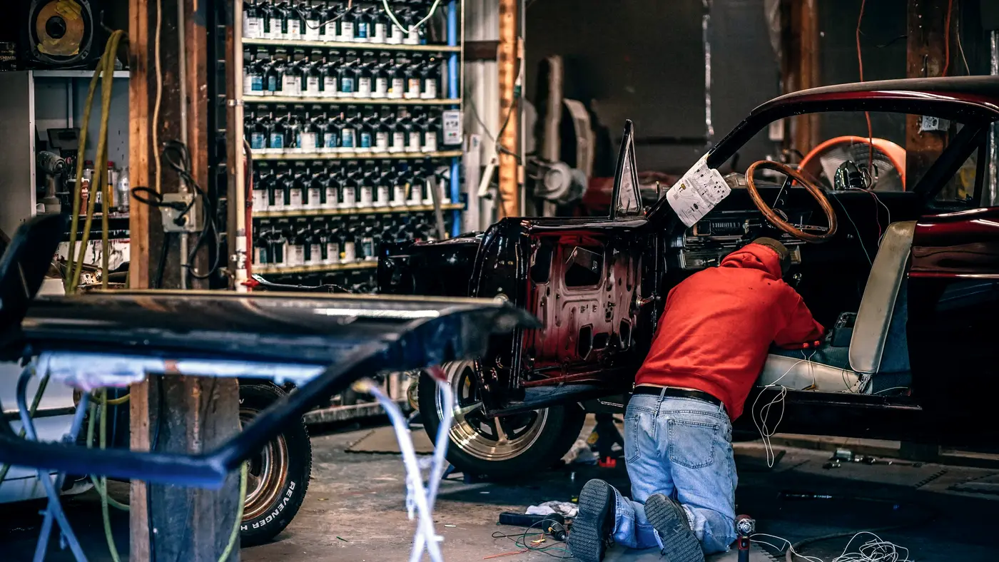 Mechanic working under a car in an auto repair shop
