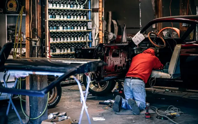 Mechanic working under a car in an auto repair shop