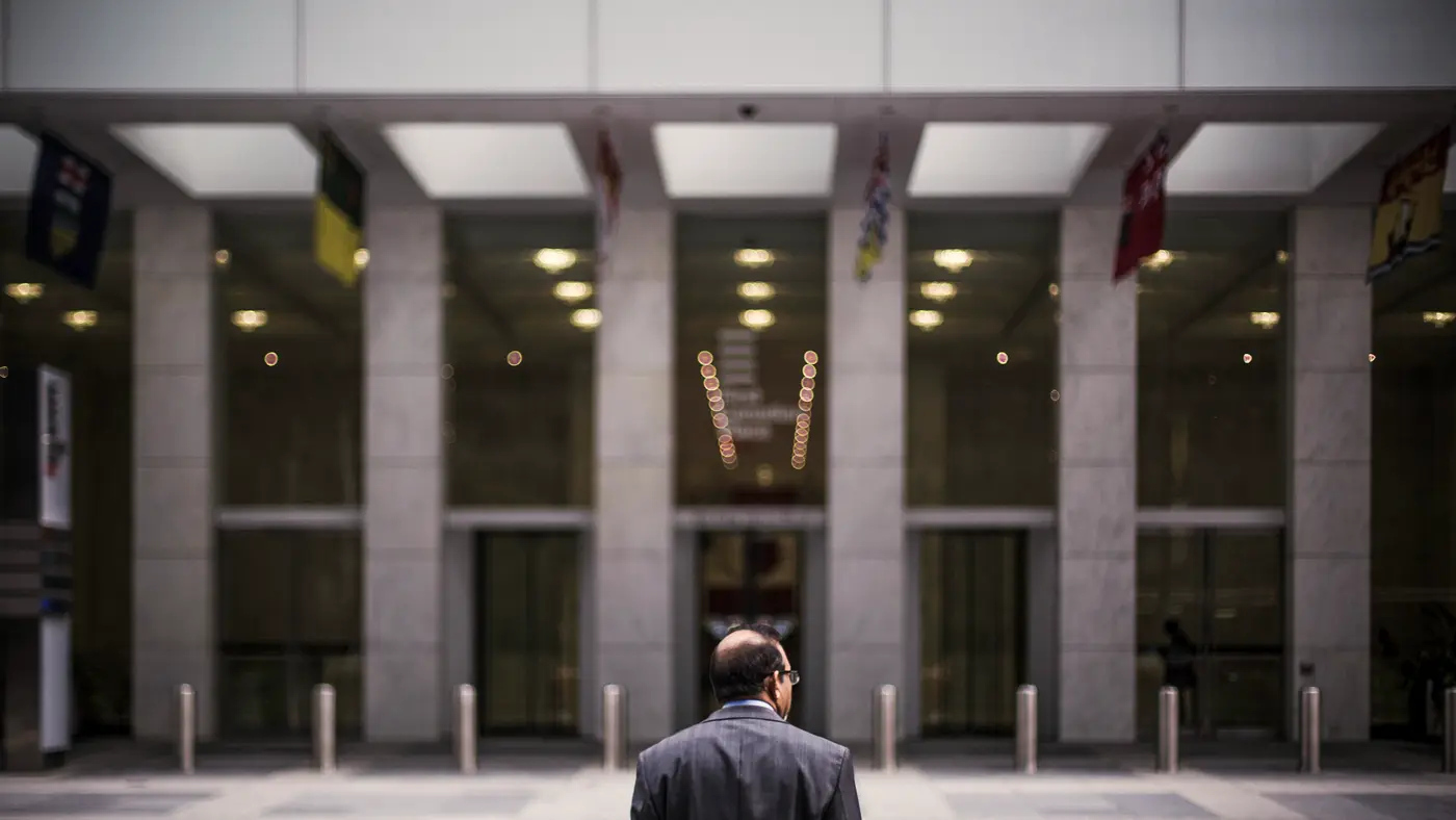 Man in a suit walking toward the entrance of an office building