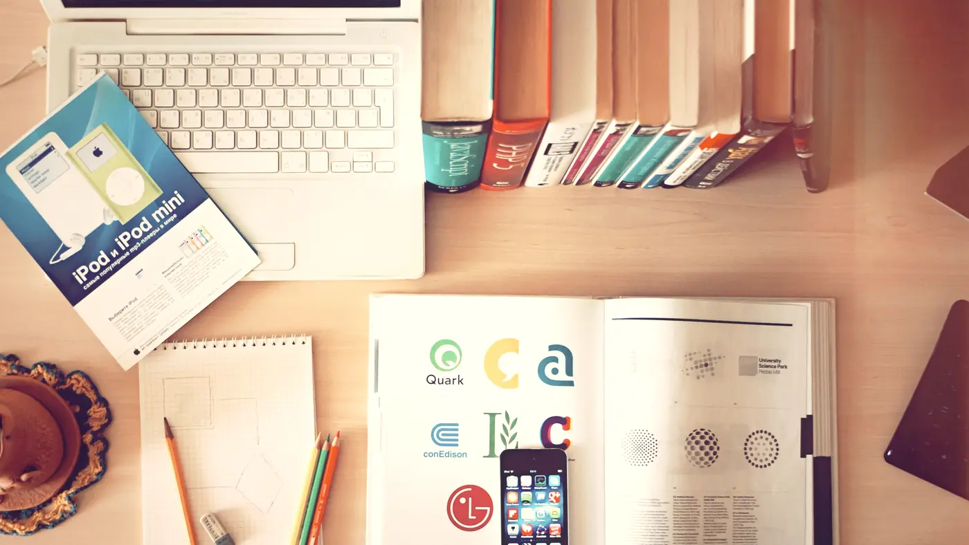 Overhead view of notebooks and papers spread across a desk