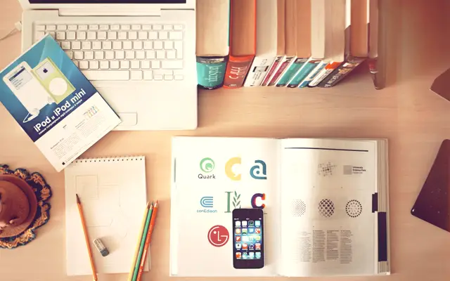 Overhead view of notebooks and papers spread across a desk