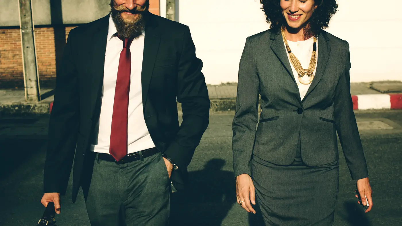 Businessman and businesswoman walking together outdoors