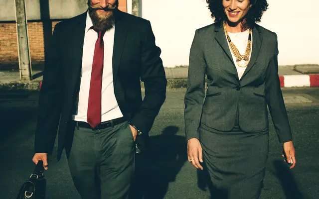 Businessman and businesswoman walking together outdoors