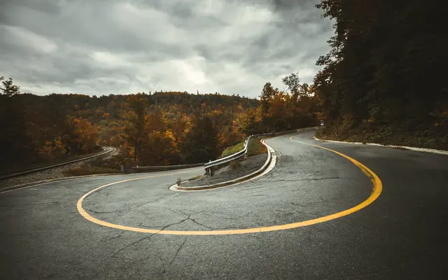 Aerial view of a road making a tight hairpin turn through the forest