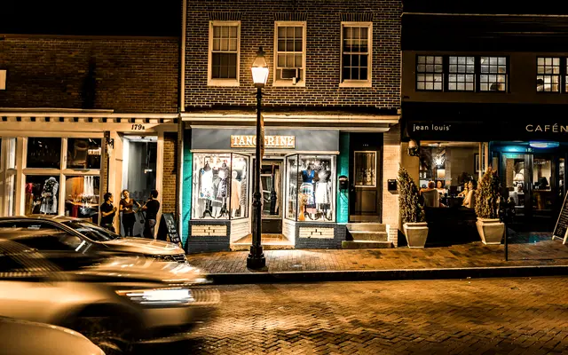 Row of lit brick storefronts on a main street at night