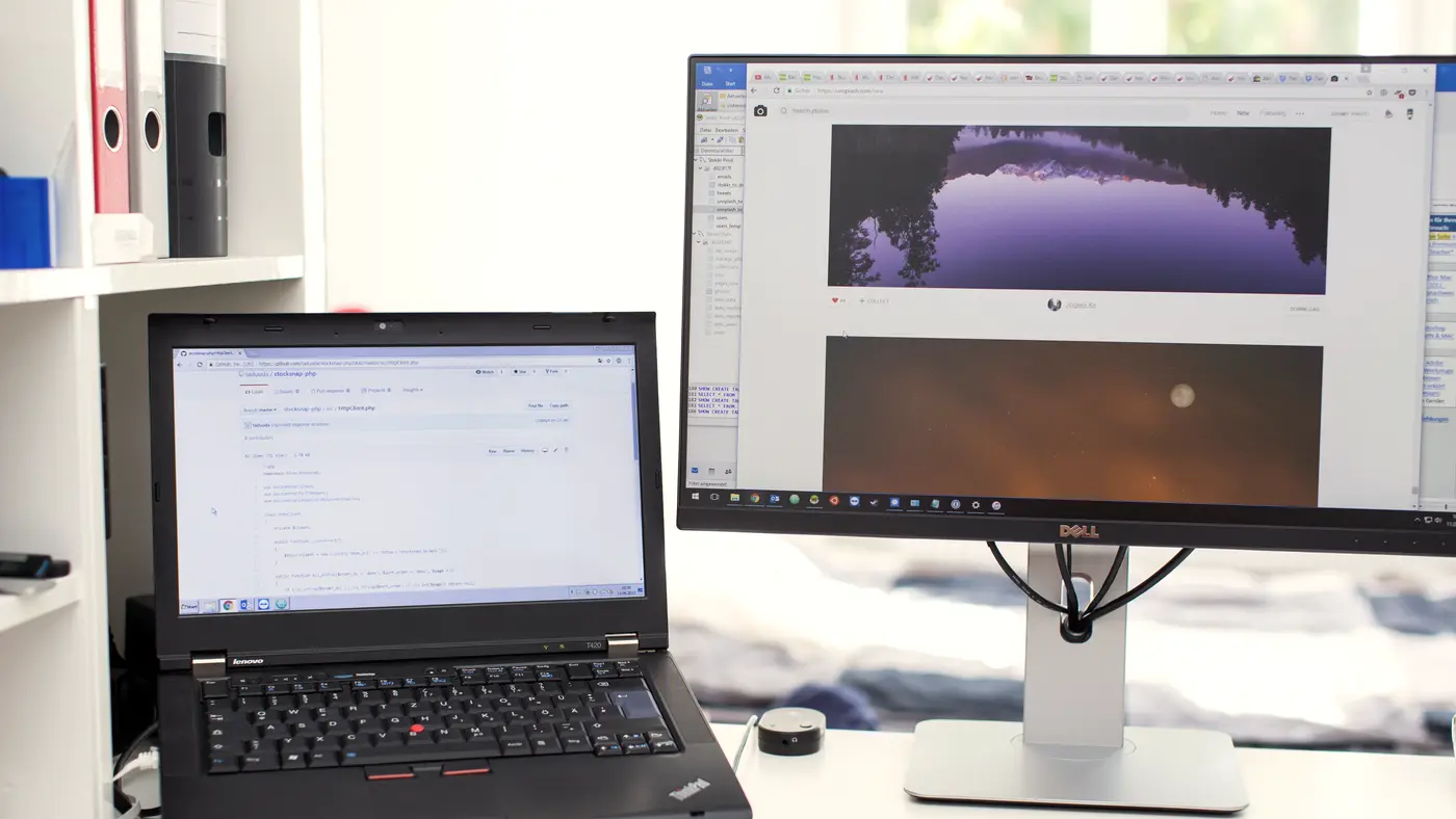 Laptop and monitor showing charts on an office desk