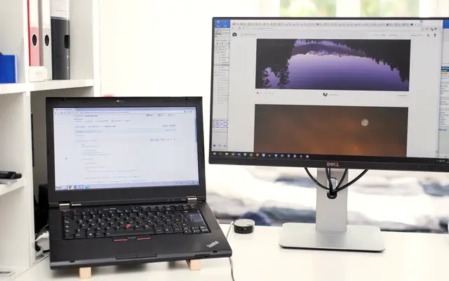Laptop and monitor showing charts on an office desk