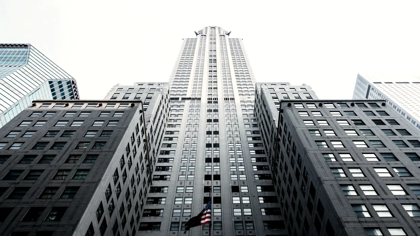 Looking up at a tall skyscraper between office towers
