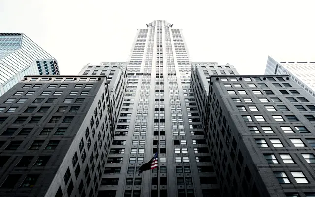 Looking up at a tall skyscraper between office towers