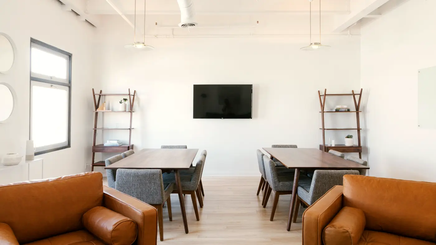 Open office space with a long meeting table and lounge chairs
