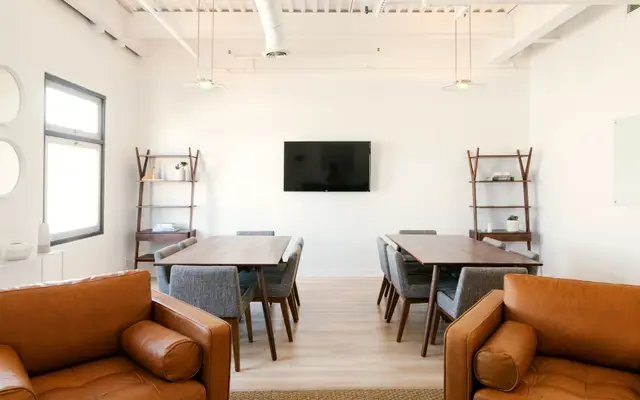 Open office space with a long meeting table and lounge chairs
