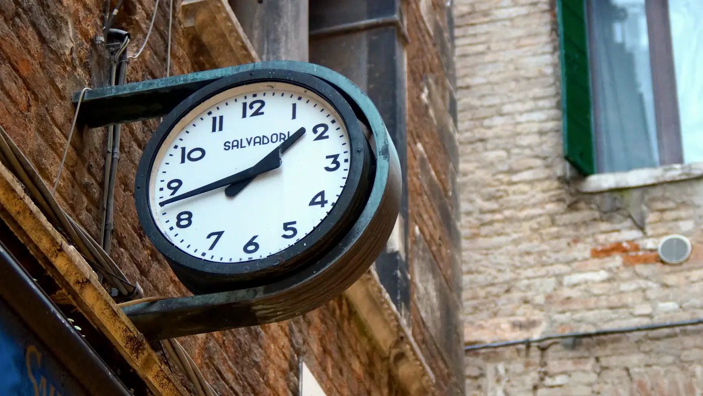 Round wall clock mounted on a brick building