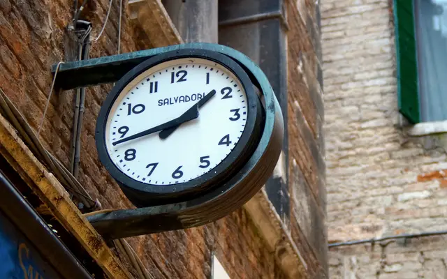 Round wall clock mounted on a brick building